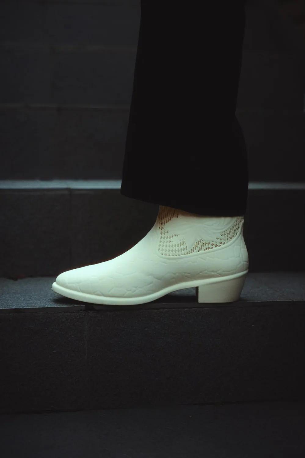 White printed cowboy boot worn on a stair